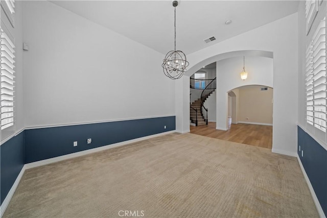 8840 Greenlawn St, Riverside, CA 92508 - empty room with carpet floors, a chandelier, arched walkways, and plenty of natural light