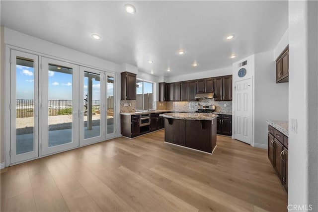 8840 Greenlawn St, Riverside, CA 92508 - kitchen featuring french doors, dark brown cabinetry, a kitchen island, tasteful backsplash, and stove
