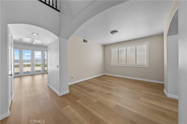 8840 Greenlawn St, Riverside, CA 92508 - empty room featuring arched walkways, light wood-style flooring, and baseboards