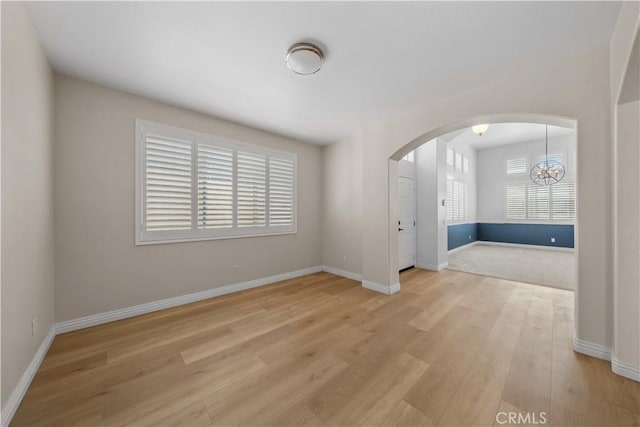 8840 Greenlawn St, Riverside, CA 92508 - empty room featuring arched walkways, wood finished floors, a chandelier, and baseboards