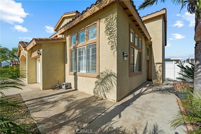 8840 Greenlawn St, Riverside, CA 92508 - view of side of property featuring a tile roof, stucco siding, and a patio area