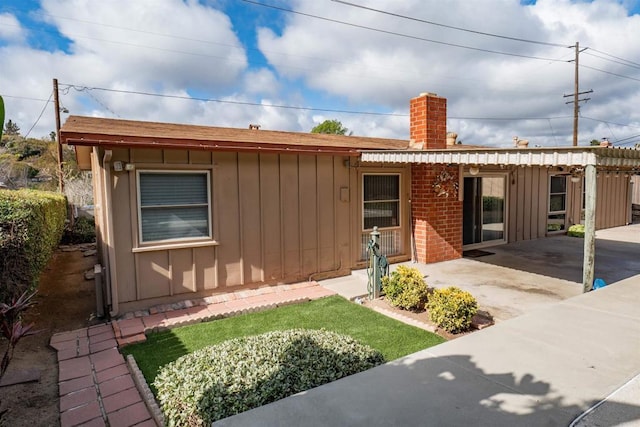 5283 Chollas Pkwy, San Diego, CA 92105 - ranch-style home featuring board and batten siding, a chimney, a patio, and roof with shingles