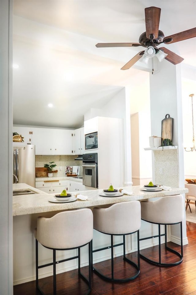 5283 Chollas Pkwy, San Diego, CA 92105 - kitchen with appliances with stainless steel finishes, a breakfast bar area, a peninsula, and white cabinets