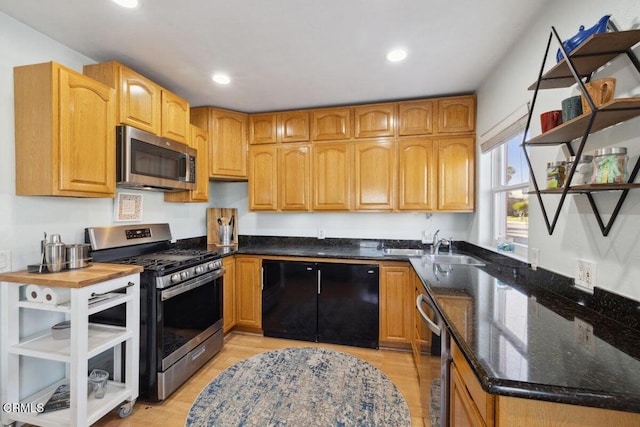 3701 Sunset Ln, Oxnard, CA 93035 - kitchen featuring stainless steel appliances, dark stone countertops, recessed lighting, a sink, and light wood finished floors