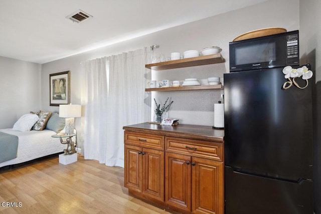 3701 Sunset Ln, Oxnard, CA 93035 - bedroom featuring black fridge and light wood-style floors