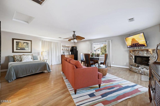 3701 Sunset Ln, Oxnard, CA 93035 - living area with a stone fireplace, attic access, wood finished floors, a ceiling fan, and baseboards