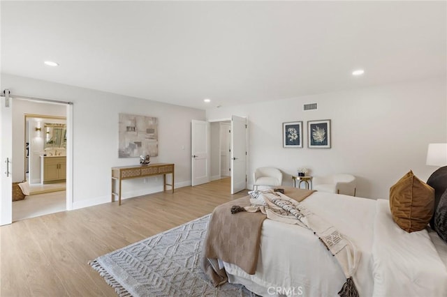 7848 Calmcrest Dr, Downey, CA 90240 - bedroom featuring recessed lighting, wood finished floors, a barn door, baseboards, and connected bathroom