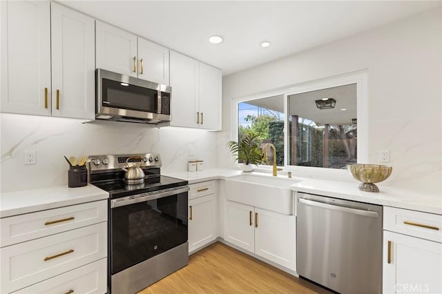 7848 Calmcrest Dr, Downey, CA 90240 - kitchen featuring appliances with stainless steel finishes, a sink, white cabinets, light countertops, and recessed lighting