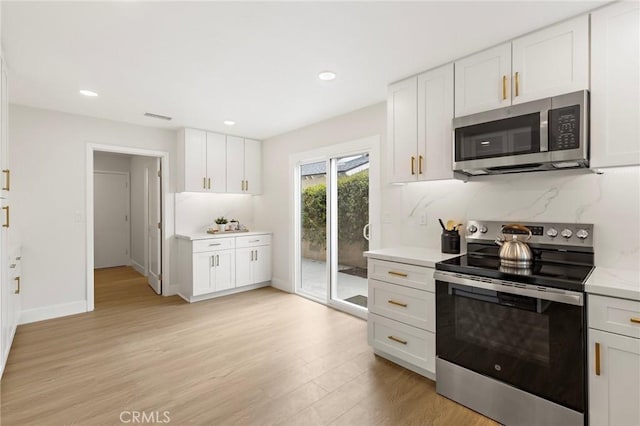 7848 Calmcrest Dr, Downey, CA 90240 - kitchen with stainless steel appliances, light wood finished floors, light countertops, white cabinets, and recessed lighting