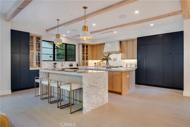 4634 Vesper Ave, Sherman Oaks, CA 91403 - kitchen featuring a spacious island, wall chimney range hood, beam ceiling, light wood finished floors, and backsplash