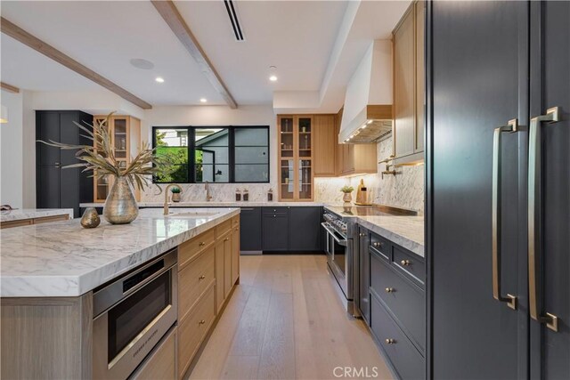 4634 Vesper Ave, Sherman Oaks, CA 91403 - kitchen featuring appliances with stainless steel finishes, custom exhaust hood, beamed ceiling, decorative backsplash, and light stone counters