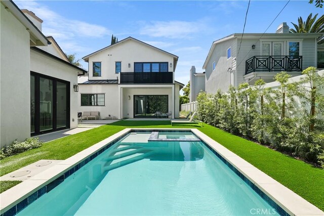 4634 Vesper Ave, Sherman Oaks, CA 91403 - rear view of property with a balcony, a standing seam roof, a lawn, a patio, and stucco siding