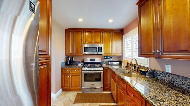 14862 Temple Ave, La Puente, CA 91744 - kitchen with appliances with stainless steel finishes, a sink, dark stone countertops, brown cabinetry, and recessed lighting
