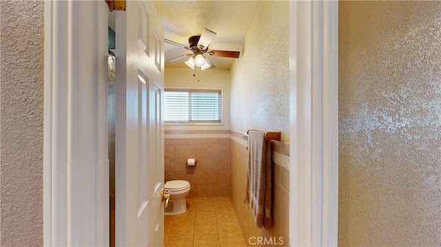 14862 Temple Ave, La Puente, CA 91744 - bathroom featuring toilet, tile patterned flooring, a ceiling fan, tile walls, and a wainscoted wall