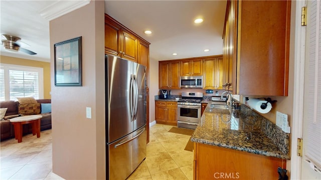 14862 Temple Ave, La Puente, CA 91744 - kitchen featuring appliances with stainless steel finishes, a sink, dark stone counters, brown cabinetry, and crown molding