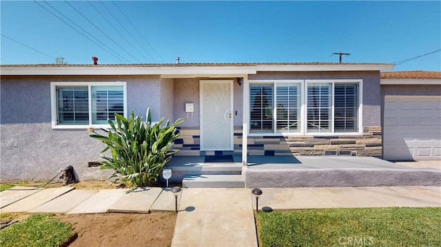 14862 Temple Ave, La Puente, CA 91744 - doorway to property with stucco siding, a garage, and stone siding
