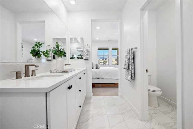 1101 Lasso Way Unit 303, Rancho Mission Viejo, CA 92694 - ensuite bathroom with double vanity, toilet, marble look tile flooring, baseboards, and recessed lighting