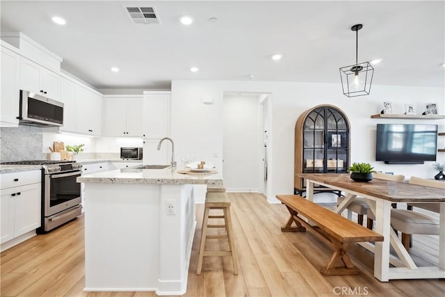 1101 Lasso Way Unit 303, Rancho Mission Viejo, CA 92694 - kitchen with stainless steel appliances, a sink, light wood-type flooring, white cabinets, and recessed lighting