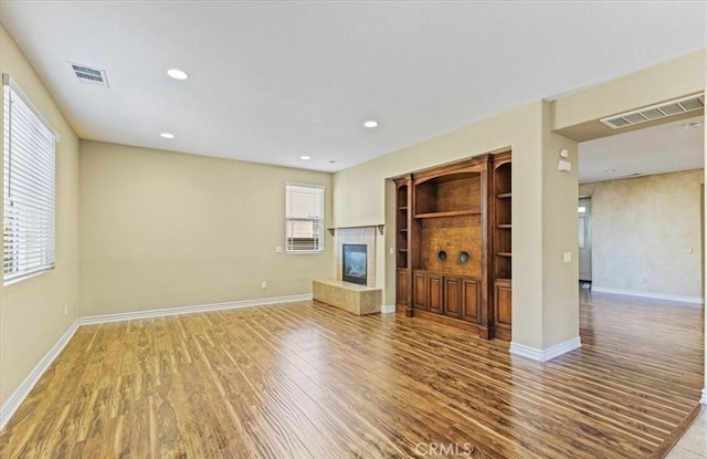 28229 Shirley Ln, Saugus, CA 91350 - unfurnished living room featuring wood finished floors, a tiled fireplace, baseboards, and recessed lighting