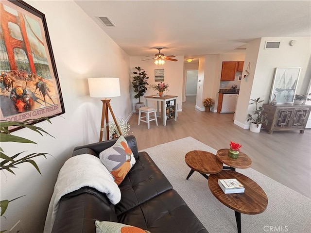 16387 De Anza Cir Unit Ci60, Huntington Beach, CA 92649 - living room with light wood-style floors, a ceiling fan, and baseboards