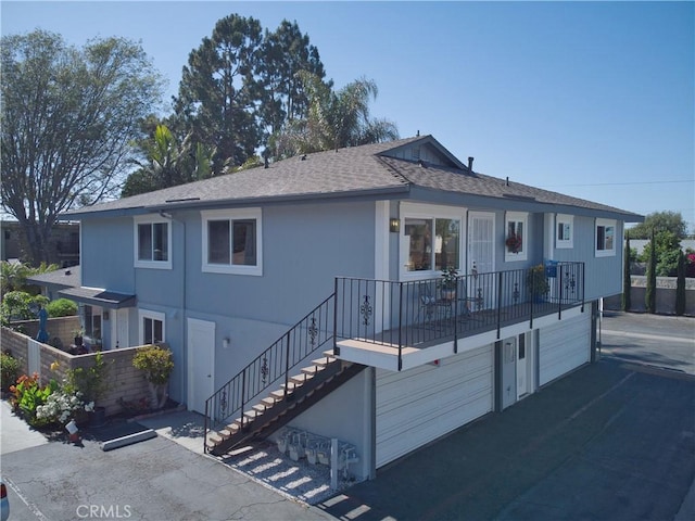 16387 De Anza Cir Unit Ci60, Huntington Beach, CA 92649 - view of front facade featuring stairway, an attached garage, roof with shingles, and asphalt driveway