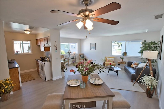 16387 De Anza Cir Unit Ci60, Huntington Beach, CA 92649 - living area with light wood finished floors, a ceiling fan, and baseboards