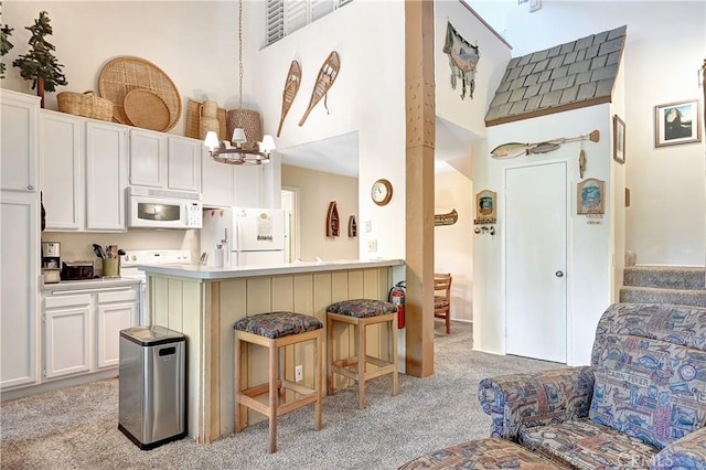 261 Lakeview Blvd Unit 54, Mammoth Lakes, CA 93546 - kitchen with white appliances, light colored carpet, a breakfast bar, a towering ceiling, and white cabinetry