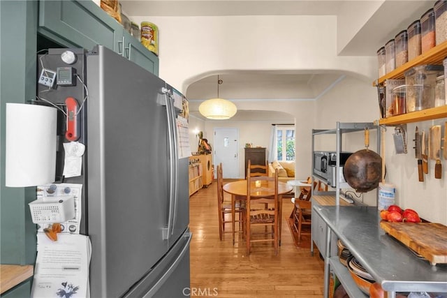 225 E 56th St, Long Beach, CA 90805 - kitchen with appliances with stainless steel finishes, arched walkways, green cabinets, and light wood-style floors
