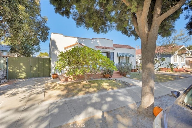 225 E 56th St, Long Beach, CA 90805 - mediterranean / spanish-style house with stucco siding, a gate, and a tile roof
