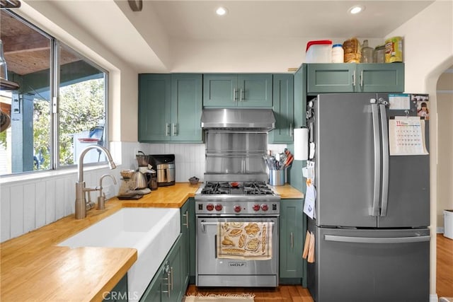 225 E 56th St, Long Beach, CA 90805 - kitchen with stainless steel appliances, green cabinetry, extractor fan, decorative backsplash, and recessed lighting