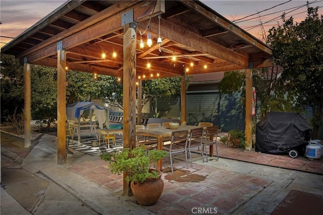 225 E 56th St, Long Beach, CA 90805 - patio terrace at dusk with grilling area, a patio, outdoor dining space, and a gazebo