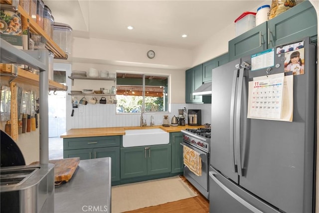 225 E 56th St, Long Beach, CA 90805 - kitchen featuring appliances with stainless steel finishes, green cabinetry, butcher block counters, backsplash, and recessed lighting