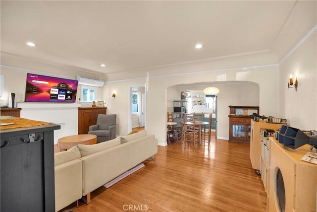 225 E 56th St, Long Beach, CA 90805 - living room featuring arched walkways, light wood-style flooring, crown molding, recessed lighting, and washer / dryer