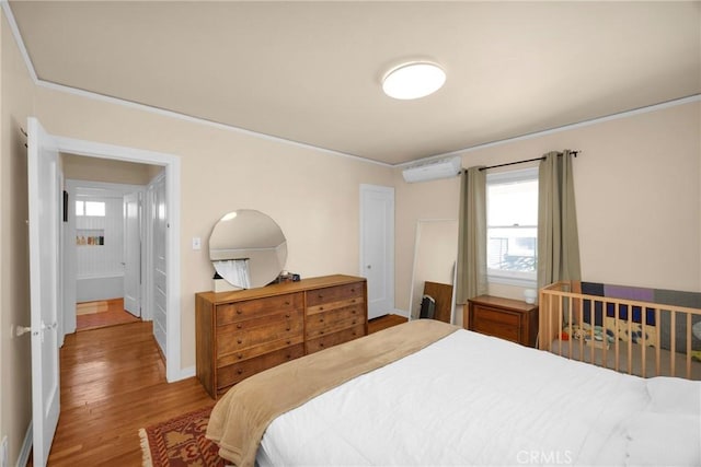 225 E 56th St, Long Beach, CA 90805 - bedroom with a wall unit AC, wood finished floors, multiple windows, and crown molding