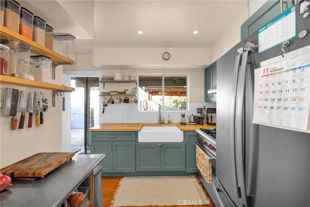 225 E 56th St, Long Beach, CA 90805 - kitchen with appliances with stainless steel finishes, open shelves, green cabinets, butcher block counters, and recessed lighting