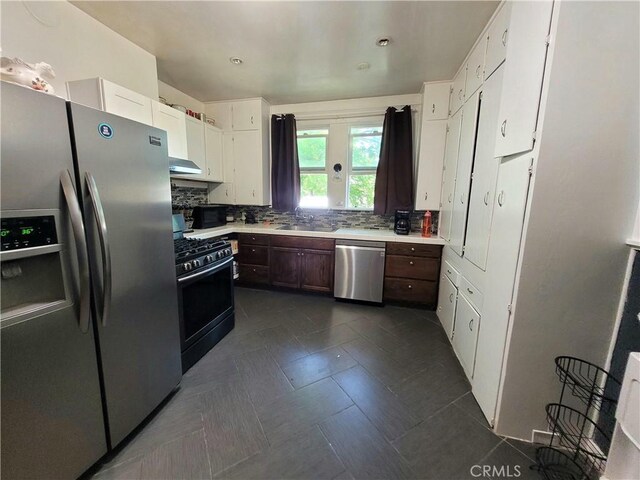 1948 K St, Merced, CA 95340 - kitchen featuring stainless steel appliances, a sink, light countertops, decorative backsplash, and white cabinetry