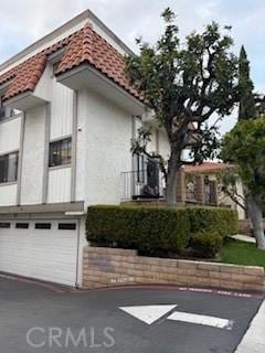 2208 N N Broadway Unit 33, Santa Ana, CA 92706 - view of property exterior with a tiled roof, stucco siding, and a garage