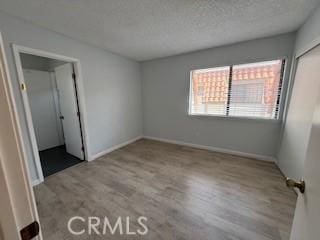 2208 N N Broadway Unit 33, Santa Ana, CA 92706 - unfurnished bedroom with wood finished floors, a closet, baseboards, and a textured ceiling