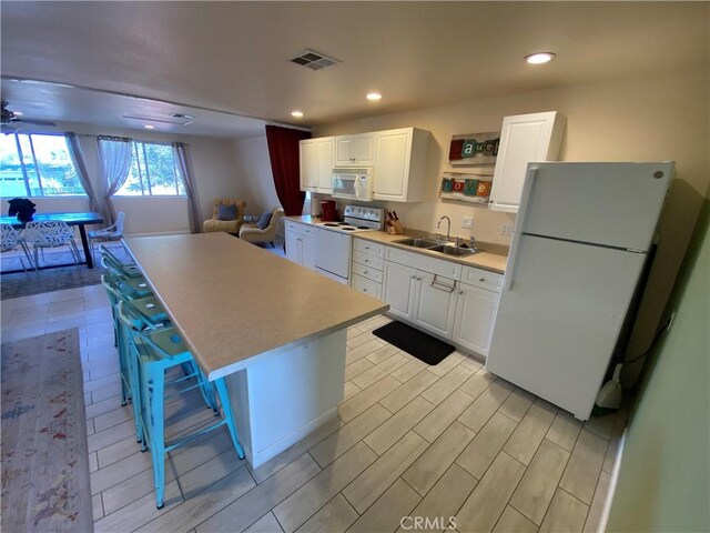 35450 Calle Nopal, Temecula, CA 92592 - kitchen with white appliances, a center island, white cabinetry, light countertops, and recessed lighting