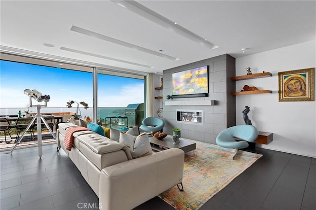1088 Del Mar Ave, Laguna Beach, CA 92651 - living area featuring a large fireplace, floor to ceiling windows, and dark tile patterned flooring