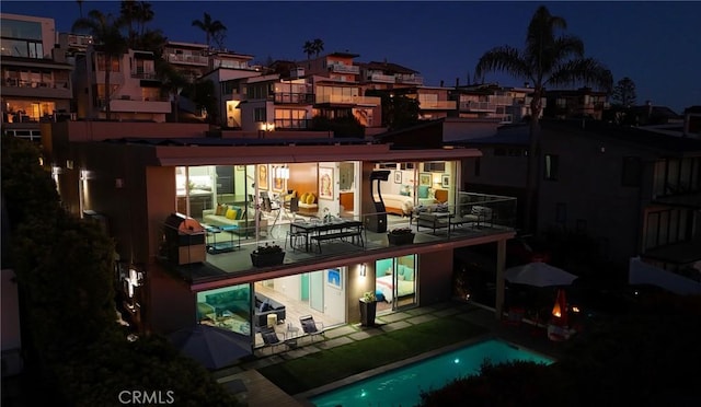 1088 Del Mar Ave, Laguna Beach, CA 92651 - back of house at twilight featuring a patio, an outdoor pool, and a balcony