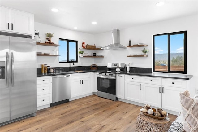 1561 Shoshone Valley Rd Unit 29, Palms, CA 92277 - kitchen featuring open shelves, stainless steel appliances, wall chimney range hood, a sink, and dark countertops