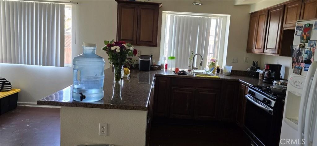 25651 Dracaea Ave, Moreno Valley, CA 92553 - kitchen with a sink, black gas range, white fridge with ice dispenser, and healthy amount of natural light