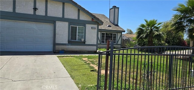 25651 Dracaea Ave, Moreno Valley, CA 92553 - view of front of home featuring a chimney, a garage, stucco siding, driveway, and a tile roof
