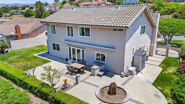 6421 Acacia Hill Dr, Yorba Linda, CA 92886 - back of property with an outdoor fire pit, a gate, and stucco siding