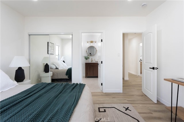 1116 W 80th St, Los Angeles, CA 90044 - bedroom featuring light wood-style floors, baseboards, and connected bathroom