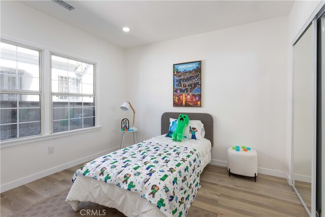 1116 W 80th St, Los Angeles, CA 90044 - bedroom with light wood finished floors, baseboards, recessed lighting, and a closet