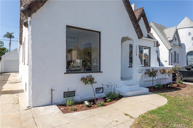 1116 W 80th St, Los Angeles, CA 90044 - view of home's exterior with stucco siding, a garage, and an outdoor structure