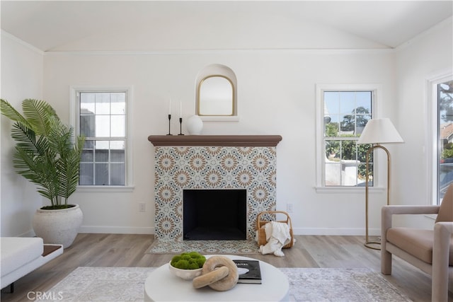 1116 W 80th St, Los Angeles, CA 90044 - living room with vaulted ceiling, wood finished floors, a tiled fireplace, and baseboards