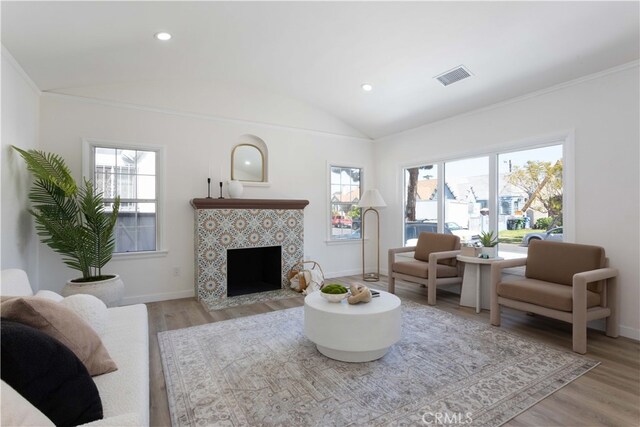 1116 W 80th St, Los Angeles, CA 90044 - living area featuring vaulted ceiling, light wood-style floors, plenty of natural light, baseboards, and a tile fireplace